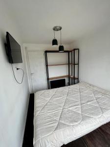 a small bedroom with a bed and a tv at CASA CONTENEDOR in Necochea