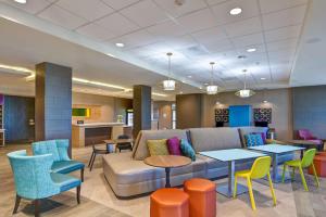a lobby with a couch and tables and chairs at Home2 Suites By Hilton Palmdale in Palmdale