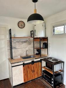 a kitchen with a sink and a clock on the wall at CASA CONTENEDOR in Necochea +18 photos