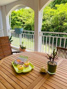 - une table en bois avec un plateau de nourriture sur la terrasse dans l'établissement L’Appart Watalibi, à Sainte-Luce
