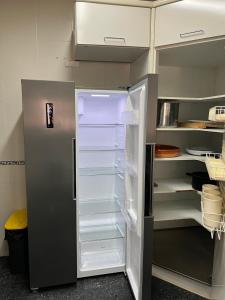 an empty refrigerator with its door open in a kitchen at Luxury Villa + Tenis in Argés