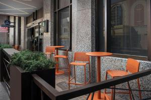 a row of orange chairs and tables on a sidewalk at Embassy Suites By Hilton Knoxville Downtown in Knoxville