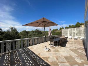 a patio with a table and an umbrella at Luxury Villa + Tenis in Argés