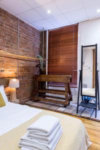 Un dormitorio con una cama y una pared de ladrillo. en City Centre Vintage Chic Studio, en Mánchester