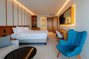 um quarto de hotel com uma cama, uma secretária e um sofá em Radisson Beach Resort Larnaca em Lárnaca