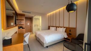 a bedroom with a bed and a desk and a chair at Radisson Beach Resort Larnaca in Larnaca