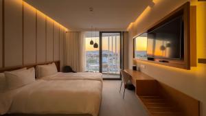 a hotel room with a bed and a flat screen tv at Radisson Beach Resort Larnaca in Larnaca