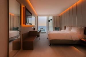 a hotel room with a bed and a desk and a bedroom at Radisson Beach Resort Larnaca in Larnaca