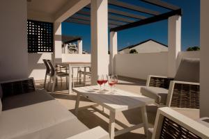 een patio met twee glazen wijn op een tafel bij Casa Laura Estepona in Estepona