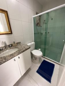 ein Bad mit einem WC, einem Waschbecken und einer Dusche in der Unterkunft Apt 3 Minutos Praia do Forte - Ar Condicionado in Cabo Frio