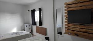 a room with a flat screen tv on a wall at Pousada Ramon in Remígio