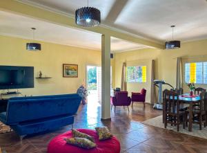 uma sala de estar com um sofá azul e uma mesa em Chacara com piscina, churrasq e WiFi em Taubate SP em Taubaté