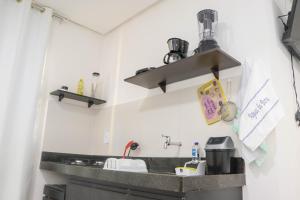 eine Küchentheke mit Spüle und Regalen in der Unterkunft Águas da Barra in Maragogi + 33 Fotos