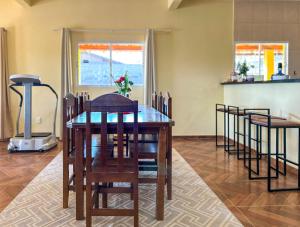 uma sala de jantar com mesa e cadeiras em Chacara com piscina, churrasq e WiFi em Taubate SP em Taubaté