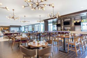 a restaurant with tables and chairs and a bar at Hilton Garden Inn Surprise Phoenix in Surprise