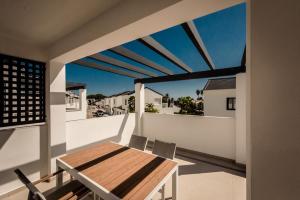 een balkon met een houten tafel en stoelen erop bij Casa Laura Estepona in Estepona