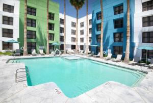 une grande piscine avec des chaises et des palmiers dans un hôtel dans l'établissement DoubleTree by Hilton Chandler Phoenix, AZ, à Chandler