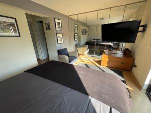 a bedroom with a bed and a flat screen tv at Departamento Delux in Santiago