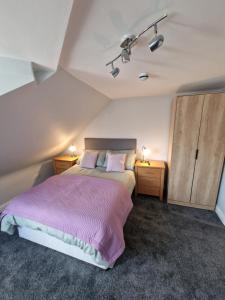 1 dormitorio con 1 cama grande y 2 mesitas de noche en Teviotside Travel Inn Ltd en Hawick