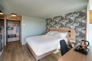 a bedroom with a large bed and a desk with a desk at Sure Hotel by Best Western Rochefort-sur-Mer in Tonnay-Charente