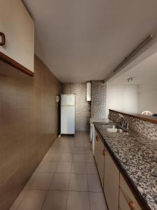 a kitchen with granite counter tops and a white refrigerator at Playa grande in Mar del Plata