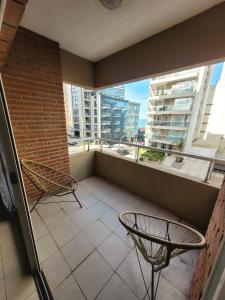 a balcony with two chairs and a large window at Playa grande in Mar del Plata