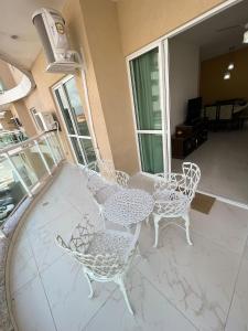 eine Terrasse mit einem Tisch und Stühlen auf einem Haus in der Unterkunft Apt 3 Minutos Praia do Forte - Ar Condicionado in Cabo Frio