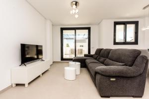 een woonkamer met een bank en een flatscreen-tv bij Casa Laura Estepona in Estepona