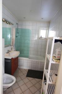 a bathroom with a sink and a toilet and a tub at King size bed, hjem med utsikt, gratis parkering in Bodø