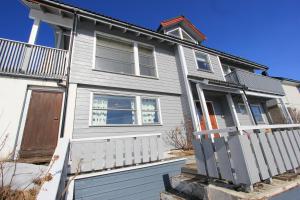 a gray house with a white fence in front of it at King size bed, hjem med utsikt, gratis parkering in Bodø