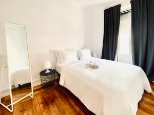 a bedroom with two white beds and a mirror at SATURdAYS in Lisbon