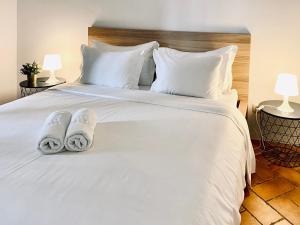 a bedroom with a white bed with slippers on it at SATURdAYS in Lisbon