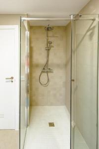 een douche met een glazen deur in de badkamer bij Casa Laura Estepona in Estepona