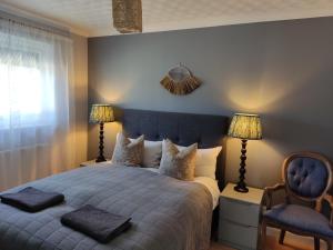 een slaapkamer met een bed met 2 lampen en een stoel bij Self-catering in Portree in Portree