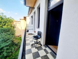 une chaise assise sur le balcon d'une maison dans l'établissement One bedroom by the Park Old Town Timisoara, à Timişoara
