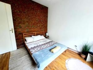 Ce lit se trouve dans une chambre dotée d'un mur en briques. dans l'établissement One bedroom by the Park Old Town Timisoara, à Timişoara
