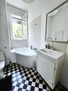 La salle de bains est pourvue d'une baignoire, d'un lavabo et de toilettes. dans l'établissement One bedroom by the Park Old Town Timisoara, à Timişoara