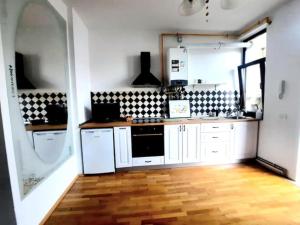 a kitchen with white appliances and a wooden floor at One bedroom by the Park Old Town Timisoara in Timişoara