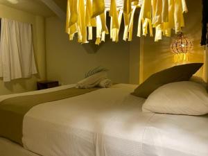 um quarto com uma grande cama branca com almofadas em Isabella Boutique Hotel em Playa del Carmen