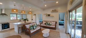 Il comprend une cuisine et un salon avec une table et des chaises. dans l'établissement Serene Holiday Home, à Rarotonga