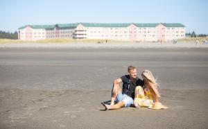 a man and a woman sitting on the beach at Quinault Beach Resort & Casino in Ocean Shores