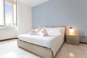 a bedroom with a white bed with towels on it at Carola's place - by Relais Di Giada in Como +37 photos
