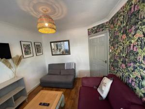 ein Wohnzimmer mit einem lila Sofa und einem Tisch in der Unterkunft the wood in London