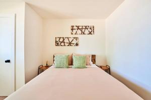 1 dormitorio con 1 cama blanca grande con almohadas verdes en Modern LUX 4 bdrm - Near Mall, Boeing, Paine Field, en Everett