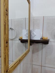 a mirror in a bathroom with towels and a shower at Pousada Linda Borboleta in Conservatória