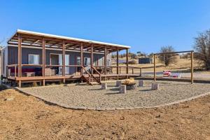 una casa en medio de un campo de tierra en Bliss Cabin @ Belaxed Farm Berridale, en Berridale