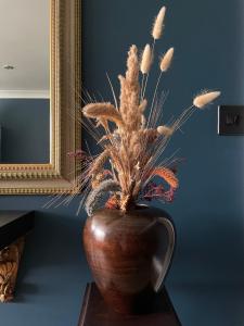 a vase with a plant in it on a table at Luxury mid century Apartment in London