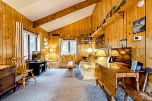 a living room with wooden walls and a couch and a tv at Rustic Escape in Franconia