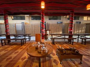 a room with tables and red and white striped poles at Adama Boutique Hotel in Mitzpe Ramon