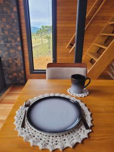 uma mesa com um prato e um copo sobre ela em Cerro Leão Estância- chalé em Bom Jardim da Serra
